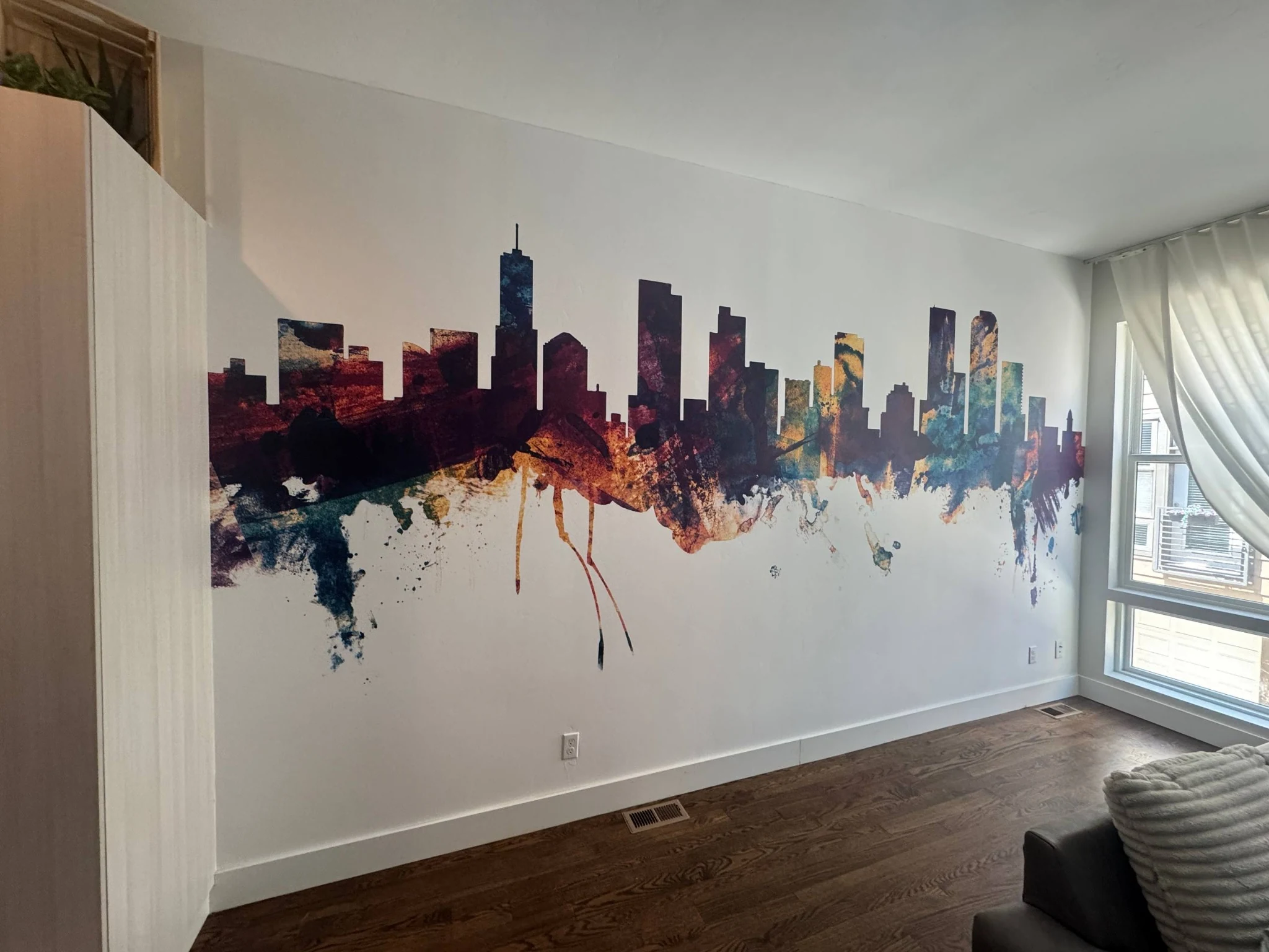 Colourful city skyline wallpaper mural across a living room accent wall
